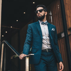 “Man wearing a stylish blue suit standing indoors”