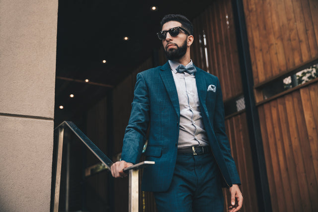 “Man wearing a stylish blue suit standing indoors”